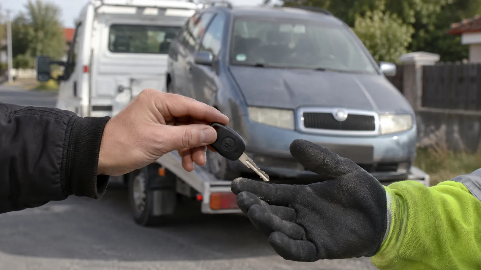 Předání klíčku od vozidla řidiči v pracovní rukavici