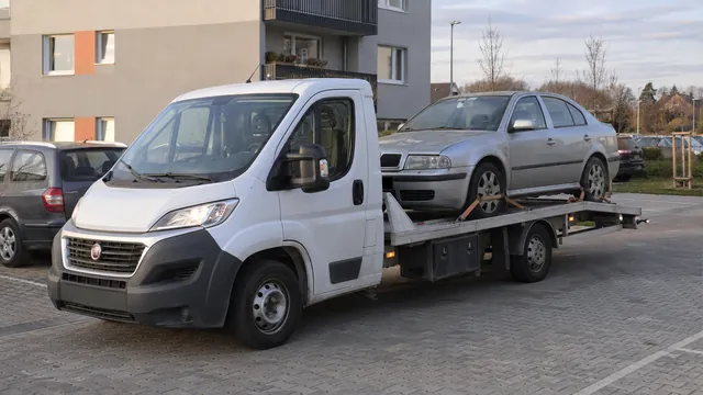 Bílý odtahový vůz s upevněným vozidlem Škoda na hliníkové plošině