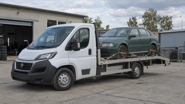 Bílý odtahový vůz s upevněným vozidlem Škoda na hliníkové plošině