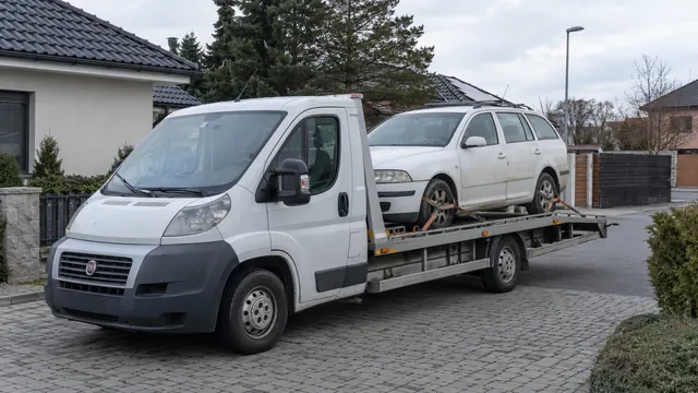 Bílý odtahový vůz s upevněným vozidlem Škoda na hliníkové plošině