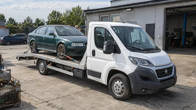Bílý odtahový vůz s upevněným vozidlem Škoda na hliníkové plošině