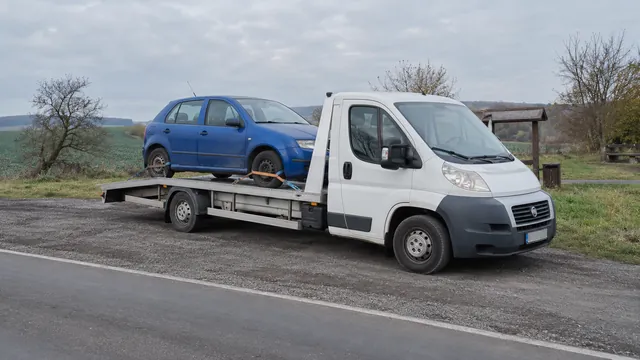 Bílý odtahový vůz s upevněným vozidlem Škoda na hliníkové plošině