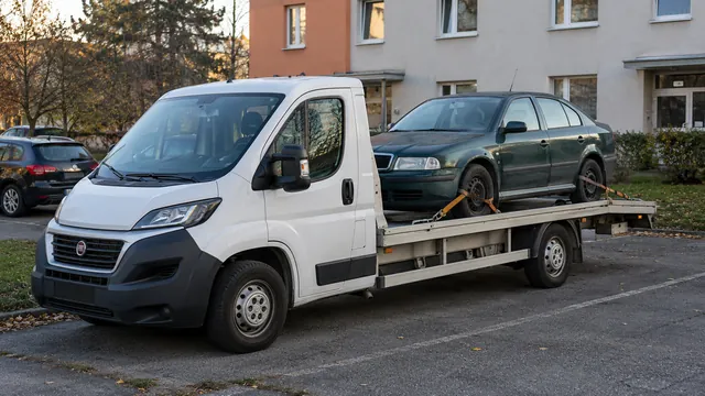 Bílý odtahový vůz s upevněným vozidlem Škoda na hliníkové plošině