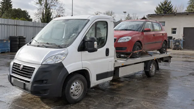 Bílý odtahový vůz s upevněným vozidlem Škoda na hliníkové plošině