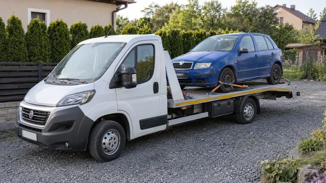 Bílý odtahový vůz s upevněným vozidlem Škoda na hliníkové plošině