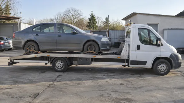 Bílý odtahový vůz s upevněným vozidlem Škoda na hliníkové plošině