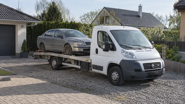 Bílý odtahový vůz s upevněným vozidlem Škoda na hliníkové plošině