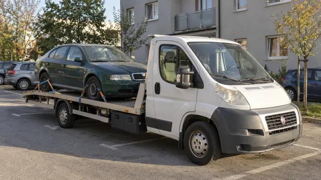 Bílý odtahový vůz s upevněným vozidlem Škoda na hliníkové plošině