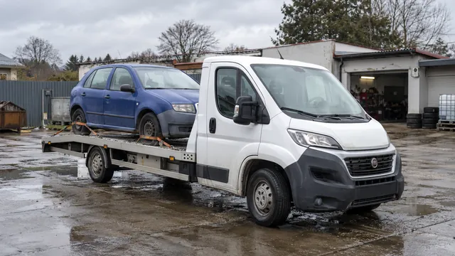 Bílý odtahový vůz s upevněným vozidlem Škoda na hliníkové plošině