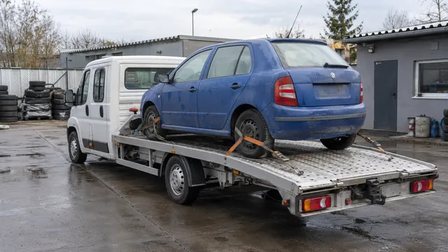Bílý odtahový vůz s upevněným vozidlem Škoda na hliníkové plošině