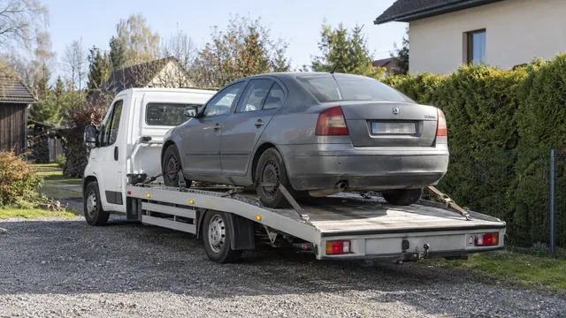 Bílý odtahový vůz s upevněným vozidlem Škoda na hliníkové plošině