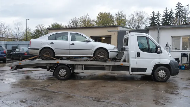 Bílý odtahový vůz s upevněným vozidlem Škoda na hliníkové plošině