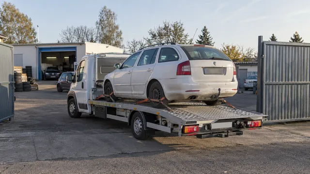Bílý odtahový vůz s upevněným vozidlem Škoda na hliníkové plošině