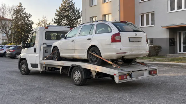 Bílý odtahový vůz s upevněným vozidlem Škoda na hliníkové plošině