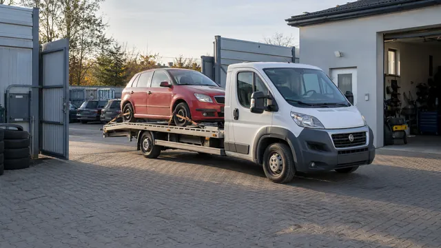 Bílý odtahový vůz s upevněným vozidlem Škoda na hliníkové plošině
