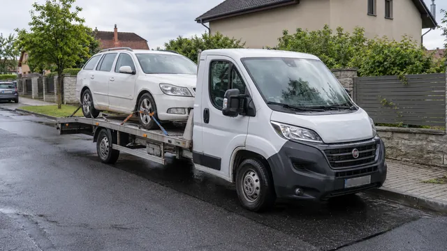 Bílý odtahový vůz s upevněným vozidlem Škoda na hliníkové plošině
