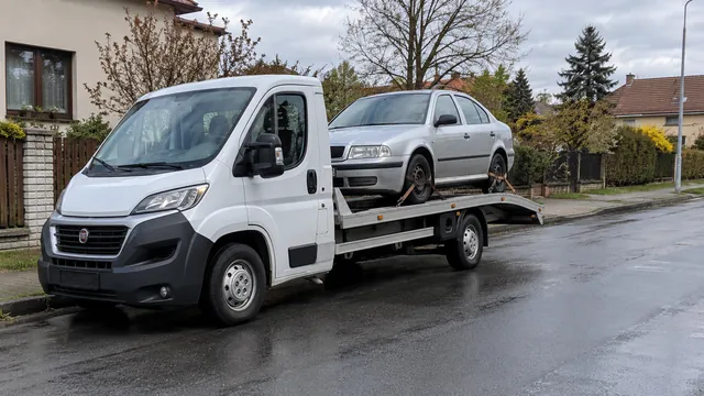 Bílý odtahový vůz s upevněným vozidlem Škoda na hliníkové plošině