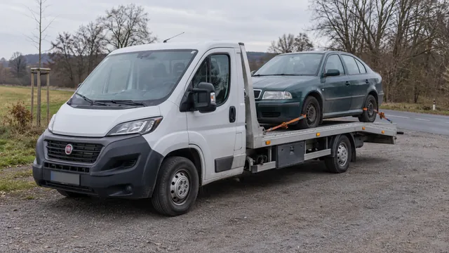 Bílý odtahový vůz s upevněným vozidlem Škoda na hliníkové plošině