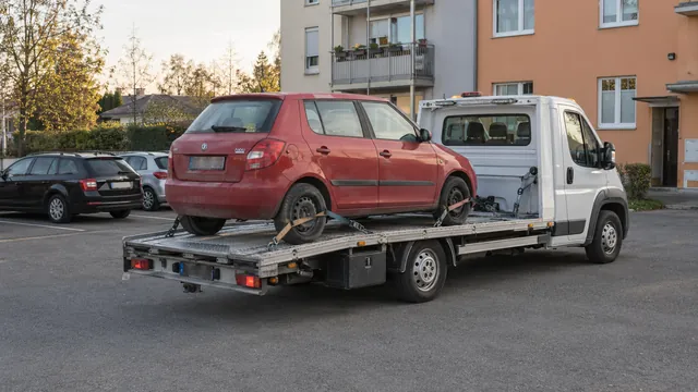 Bílý odtahový vůz s upevněným vozidlem Škoda na hliníkové plošině