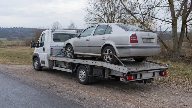 Bílý odtahový vůz s upevněným vozidlem Škoda na hliníkové plošině