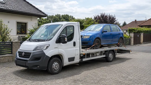 Bílý odtahový vůz s upevněným vozidlem Škoda na hliníkové plošině
