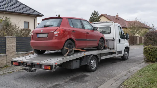 Bílý odtahový vůz s upevněným vozidlem Škoda na hliníkové plošině