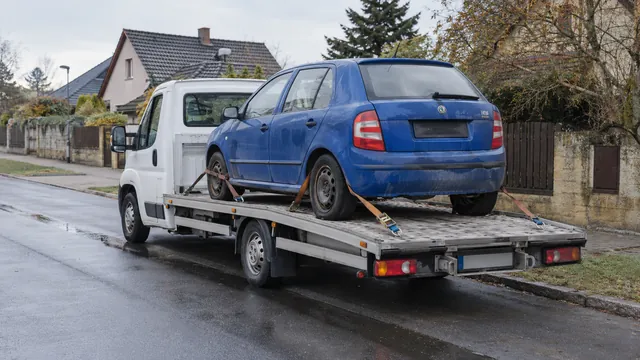 Bílý odtahový vůz s upevněným vozidlem Škoda na hliníkové plošině