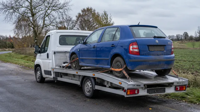 Bílý odtahový vůz s upevněným vozidlem Škoda na hliníkové plošině