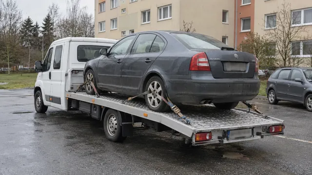 Bílý odtahový vůz s upevněným vozidlem Škoda na hliníkové plošině