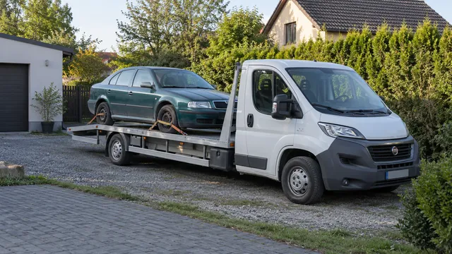 Bílý odtahový vůz s upevněným vozidlem Škoda na hliníkové plošině