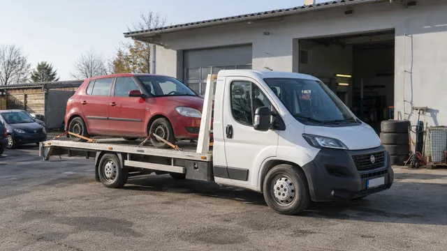 Bílý odtahový vůz s upevněným vozidlem Škoda na hliníkové plošině