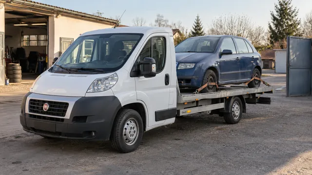 Bílý odtahový vůz s upevněným vozidlem Škoda na hliníkové plošině