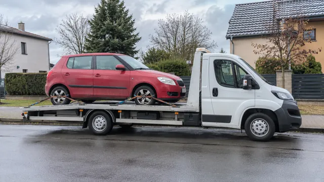 Bílý odtahový vůz s upevněným vozidlem Škoda na hliníkové plošině