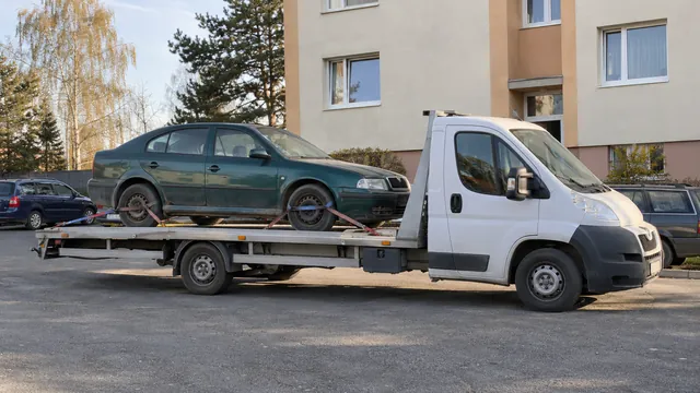 Bílý odtahový vůz s upevněným vozidlem Škoda na hliníkové plošině