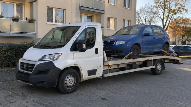 Bílý odtahový vůz s upevněným vozidlem Škoda na hliníkové plošině