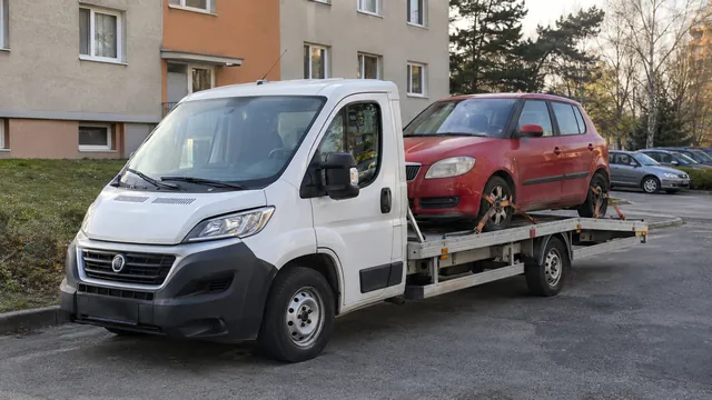 Bílý odtahový vůz s upevněným vozidlem Škoda na hliníkové plošině