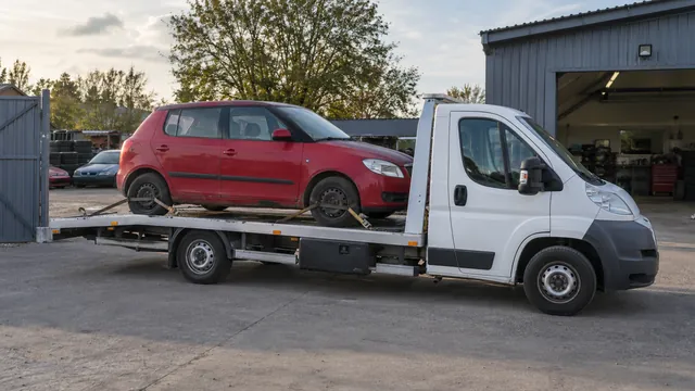 Bílý odtahový vůz s upevněným vozidlem Škoda na hliníkové plošině