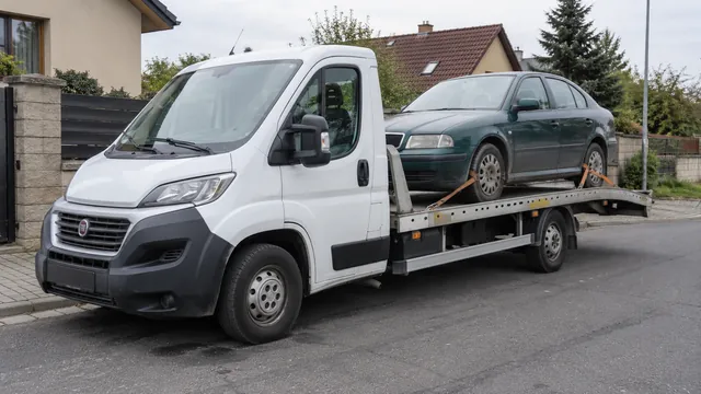 Bílý odtahový vůz s upevněným vozidlem Škoda na hliníkové plošině