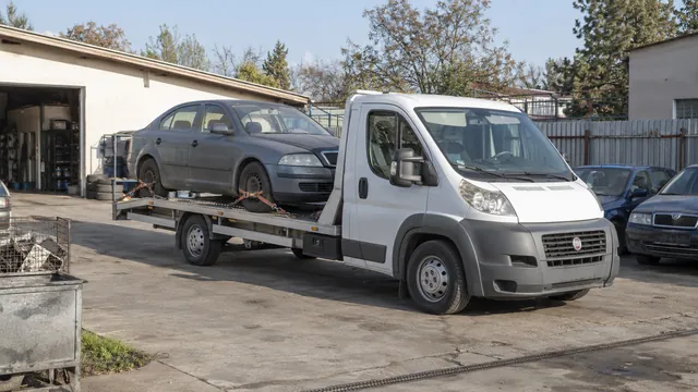Bílý odtahový vůz s upevněným vozidlem Škoda na hliníkové plošině