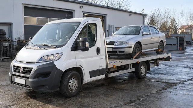 Bílý odtahový vůz s upevněným vozidlem Škoda na hliníkové plošině