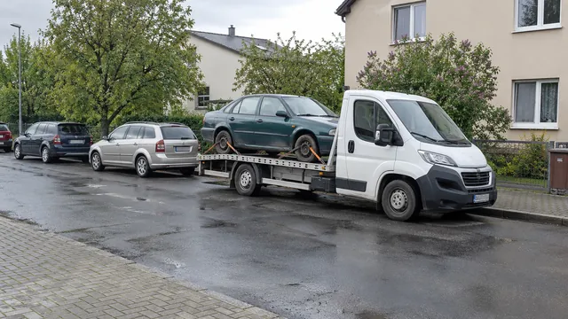 Bílý odtahový vůz s upevněným vozidlem Škoda na hliníkové plošině