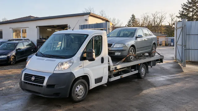 Bílý odtahový vůz s upevněným vozidlem Škoda na hliníkové plošině