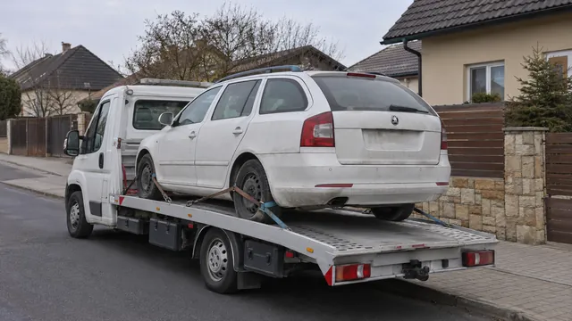 Bílý odtahový vůz s upevněným vozidlem Škoda na hliníkové plošině