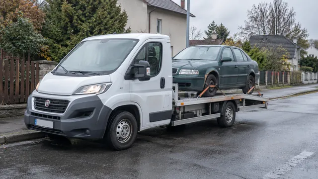Bílý odtahový vůz s upevněným vozidlem Škoda na hliníkové plošině