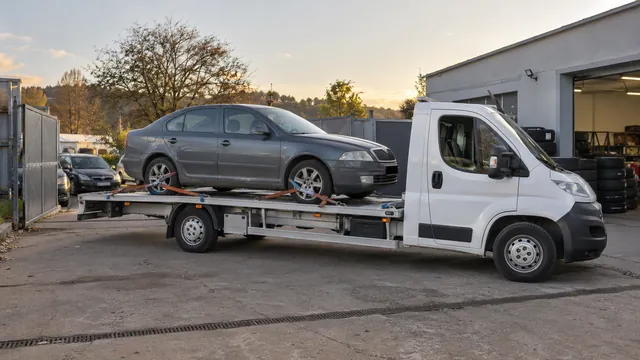 Bílý odtahový vůz s upevněným vozidlem Škoda na hliníkové plošině