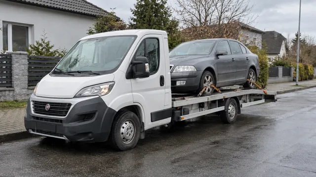 Bílý odtahový vůz s upevněným vozidlem Škoda na hliníkové plošině
