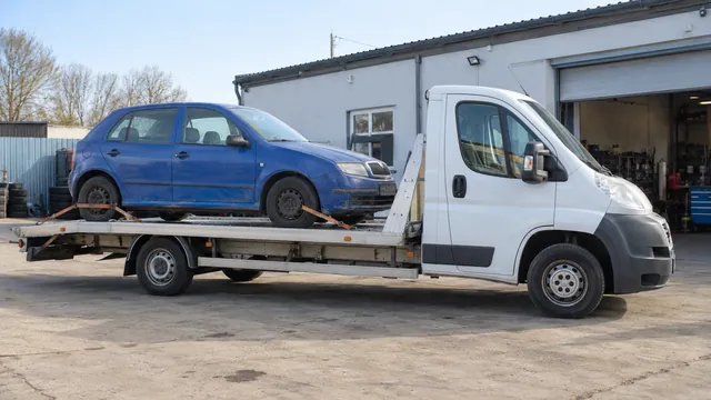 Bílý odtahový vůz s upevněným vozidlem Škoda na hliníkové plošině