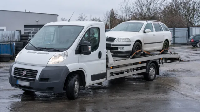 Bílý odtahový vůz s upevněným vozidlem Škoda na hliníkové plošině