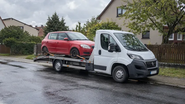 Bílý odtahový vůz s upevněným vozidlem Škoda na hliníkové plošině