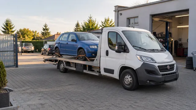 Bílý odtahový vůz s upevněným vozidlem Škoda na hliníkové plošině